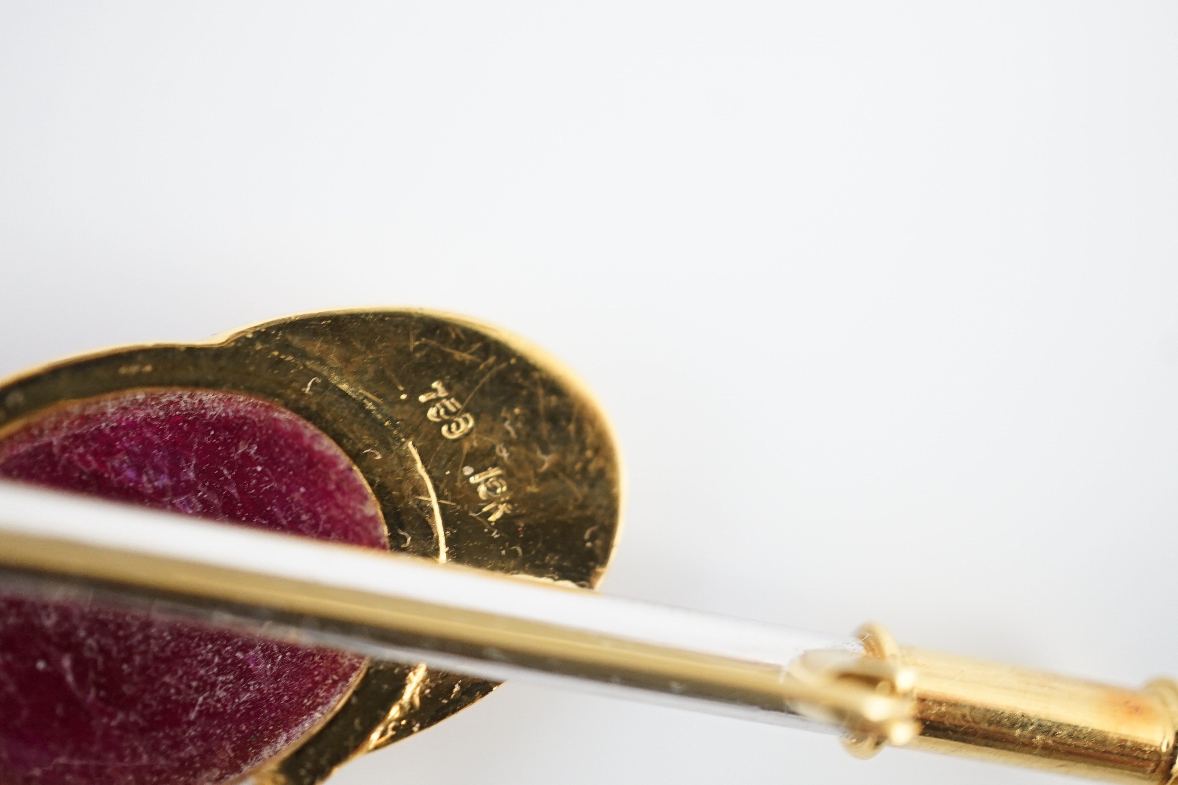 A late 20th century 18ct yellow and white gold, cabochon ruby set ‘jockey cap, riding crop and stirrups’ drop bar brooch